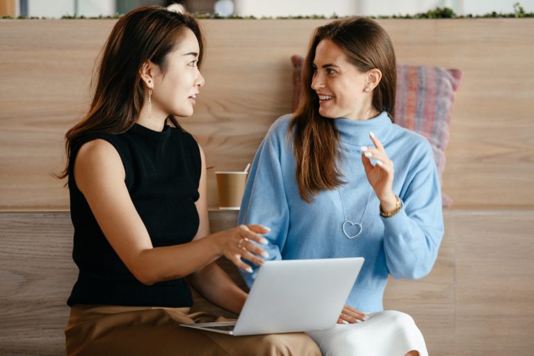 a person and a girl looking at a laptop