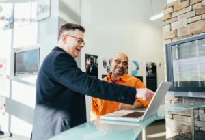 a man showing a man something on the laptop